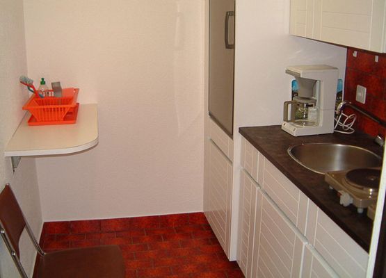 Küche mit Kühlschrank und zwei Herdplatten