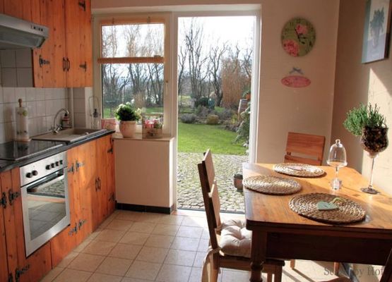 Küche mit Küchenzeile und Zugang zum Außenbereich